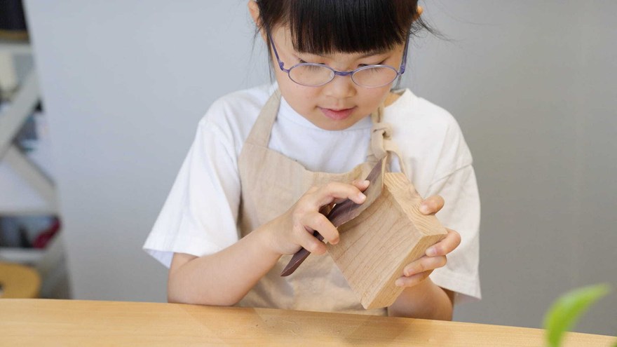 木工体験でやすりがけをする子ども