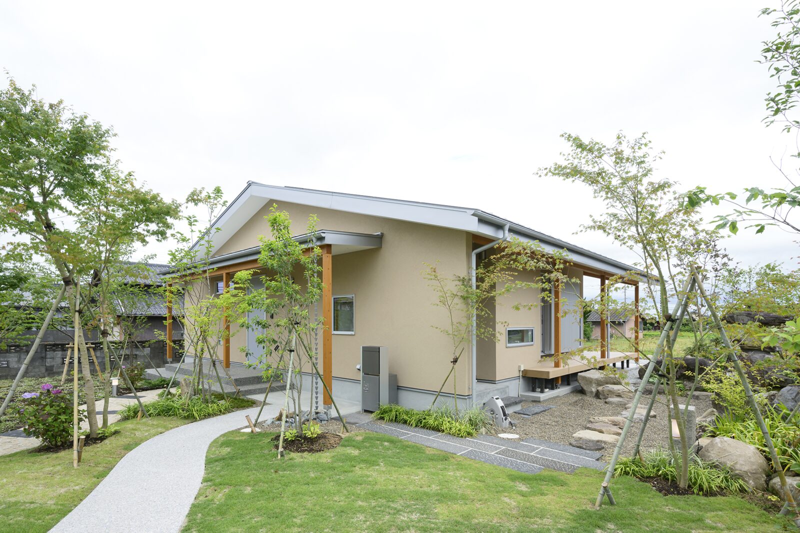 化粧柱が軒を支える塗り壁の平屋と庭